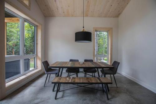 een eetkamer met een houten tafel en stoelen bij Le Boréal in Saint-Donat-de-Montcalm