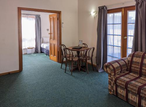 a living room with a table and a couch at Arkana Motor Inn & Terrace Apartments in Mount Gambier