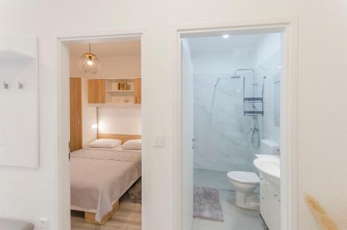 a bedroom with a bed and a bathroom with a shower at Apartment Maja with Jacuzzi in Rupe