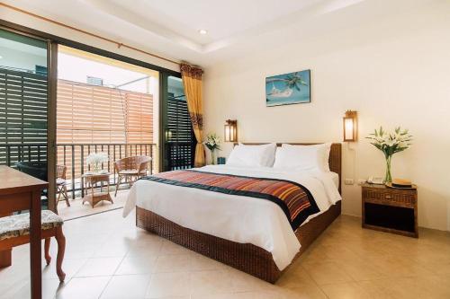 a bedroom with a large bed and a balcony at Kata Silver Sand in Kata Beach