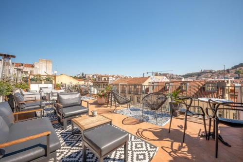 a patio with chairs and tables on a roof at The ART INN Lisbon in Lisbon
