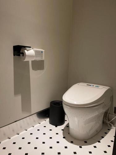 a bathroom with a white toilet and a black and white floor at Junibino Hotel Hongdae in Seoul
