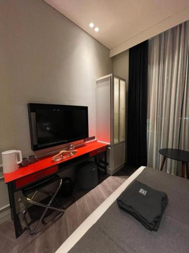 a hotel room with a red desk with a flat screen tv at Junibino Hotel Hongdae in Seoul