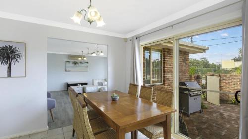 a kitchen and dining room with a wooden table and chairs at Vietta Rene Umina Beach in Umina