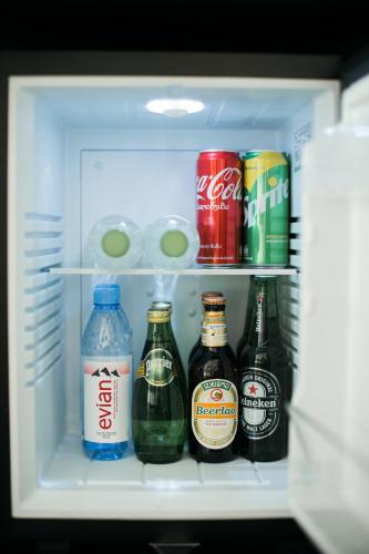 a refrigerator filled with bottles of beer and drinks at SureStay Hotel by Best Western Vientiane in Vientiane