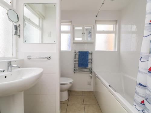 a white bathroom with a sink and a toilet at Calac Cottage in Mousehole