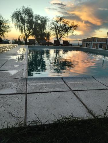 una piscina con puesta de sol en el fondo en Complejo Puesta del Sol san Luis en La Punta
