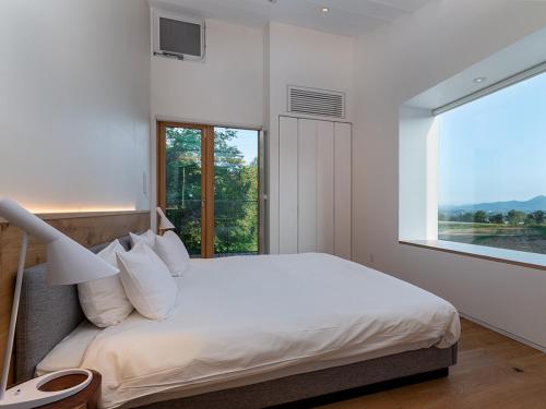 a bedroom with a large bed with a window at Yukihyo by H2 Life in Niseko