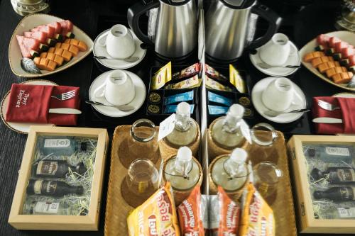 a table with food and tea pots and plates of food at SureStay Hotel by Best Western Vientiane in Vientiane