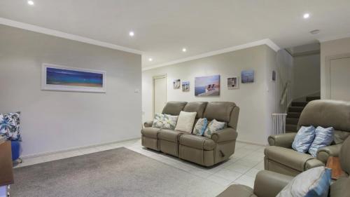 a living room with two chairs and a couch at Ocean Beach Holiday House in Ettalong Beach