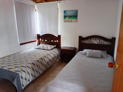 a bedroom with two beds in a room at Casa de campo San Fernando in Villeta