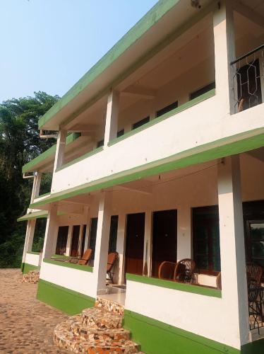 a building with chairs on the balcony at Heaven Goa Guesthouse in Benaulim