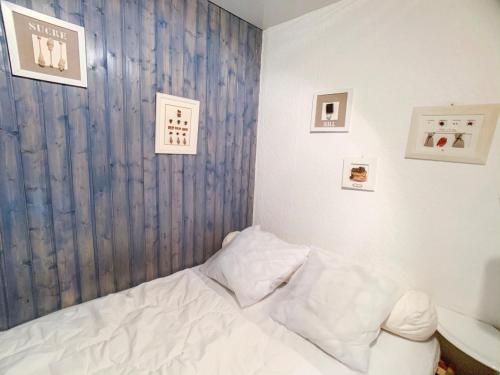 - une chambre avec un lit blanc et des photos sur le mur dans l'établissement Studio lumineux, skis aux pieds à Tignes Val Claret, balcon, proches commerces & écoles de ski - FR-1-502-499, à Tignes