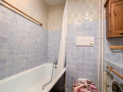 La salle de bains est pourvue de carrelage bleu, d'une baignoire et d'une douche. dans l'établissement Studio lumineux, skis aux pieds à Tignes Val Claret, balcon, proches commerces & écoles de ski - FR-1-502-499, à Tignes