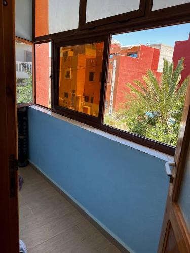ein Fenster in einem Zimmer mit Blick auf ein Gebäude in der Unterkunft Appartement / Logement Imsouane. in Imsouane