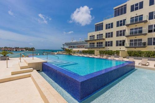 a swimming pool in front of a building at Milateo Suite in Oranjestad