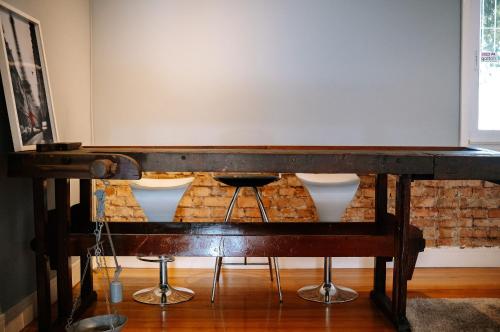 a wooden table with a bar in front of a brick wall at Prédio Histórico na Rio Branco in Caxias do Sul