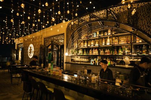 a bar in a restaurant with people sitting at it at SureStay Hotel by Best Western Vientiane in Vientiane