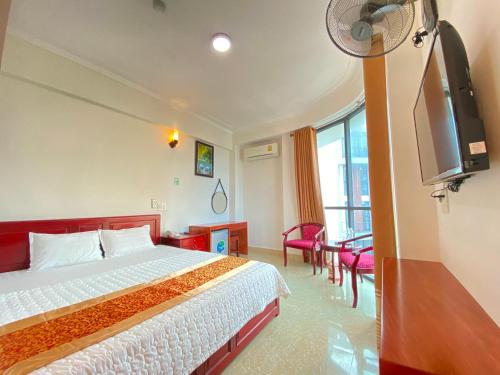 um quarto de hotel com uma cama e uma televisão de ecrã plano em Hai Dang Hotel em Cửa Lô