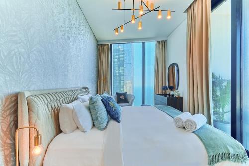 a bedroom with a large white bed with pillows at Luxury & Chic 3BD Sea-View Apartment on Marina Beach by Sea N' Rent in Dubai
