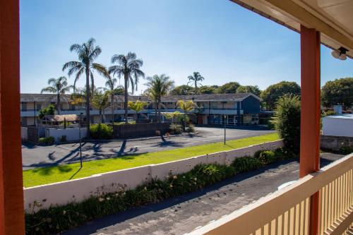 a view from the porch of a resort with palm trees at Arkana Motor Inn & Terrace Apartments in Mount Gambier