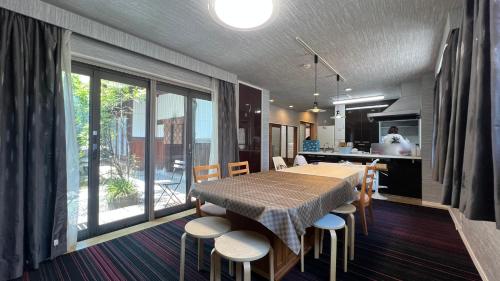 cocina y comedor con mesa y sillas en 和風庭園豪邸 en Osaka