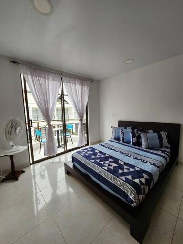 a bedroom with a bed and a large window at Elegante, hermoso, equipado en Villeta in Villeta