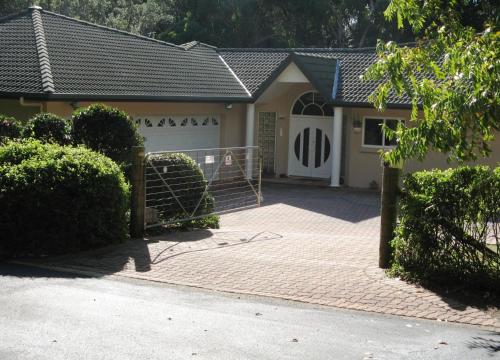 a house with a gate and a white garage at Amberlyn Escapes in Killcare