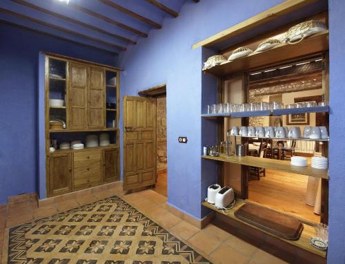 a kitchen with blue walls and wooden cabinets at Cortijo Palacete La Tala in Guadix