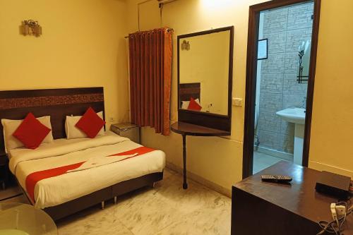 a bedroom with a bed and a sink and a mirror at Hotel Mandakini Palace in New Delhi