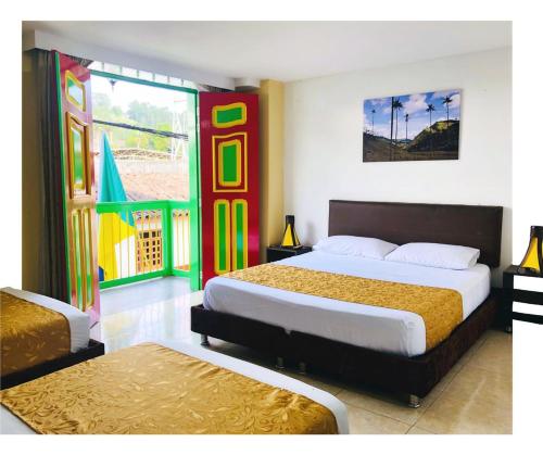 Habitación de hotel con 2 camas y ventana en HOTEL SHAMBALA, en Salento