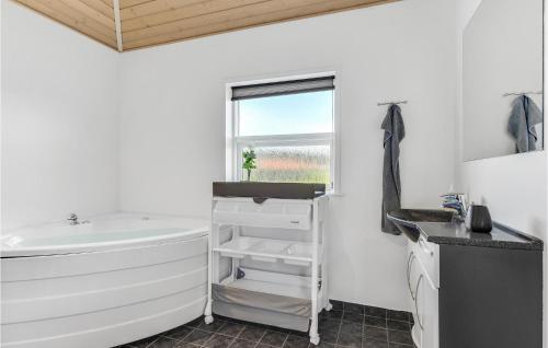 ノーポにあるAmazing Home In Nordborg With 3 Bedrooms And Wifiのバスルーム(バスタブ、シンク付)、窓が備わります。