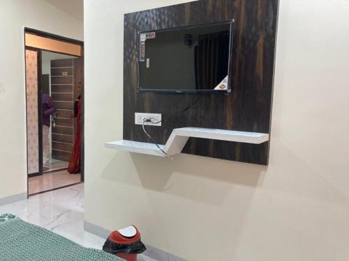 baño con espejo y TV en la pared en Hotel Sai viraj palace, en Shirdi
