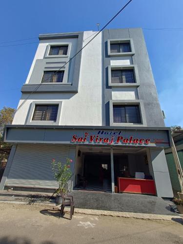 a tall white building with a sign on it at Hotel Sai viraj palace in Shirdi