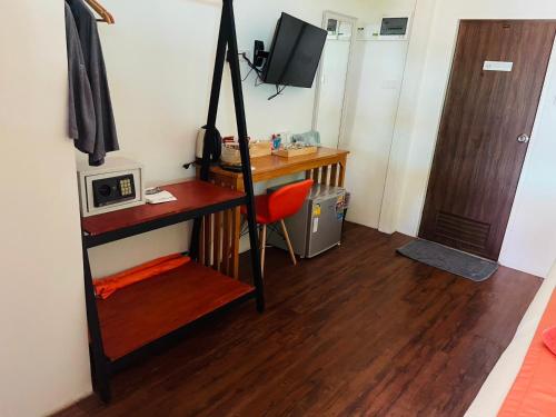 a small room with a desk and a television at Koh Jum Delight Beach in Ko Jum