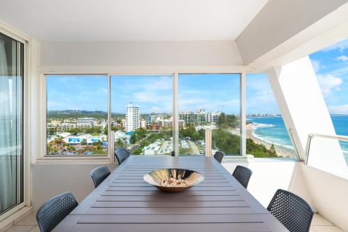a dining room with a table and views of the ocean at 84 The Spit Holiday Apartments in Mooloolaba