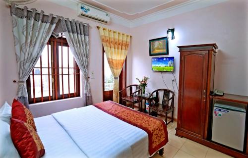 een slaapkamer met een bed, een tafel en een televisie bij Viet Nhat Hotel in Ninh Binh