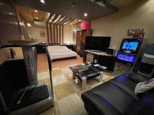 a living room with a video game machine and a couch at HOTEL　LISBON in Maibara