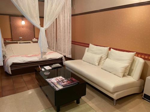 a room with two beds and a couch and a table at HOTEL　LISBON in Maibara