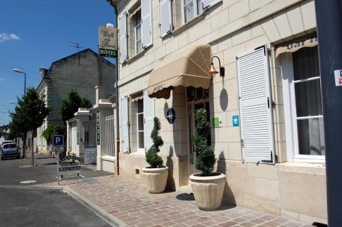 a street with two potted plants in front of a building at Belle Epoque in Chinon
