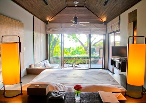 a bedroom with a large bed and a large window at Sri Panwa Phuket Luxury Pool Villa Hotel - SHA Plus in Panwa Beach