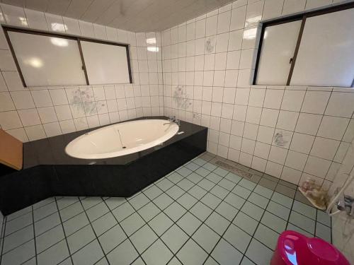 a bathroom with a bath tub and a sink at HOTEL　LISBON in Maibara