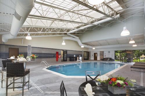 a large indoor pool with chairs and a table at Chauncey Hotel and Conference Center in Princeton