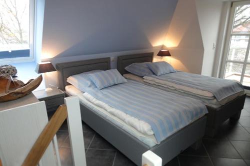 1 dormitorio con 1 cama con 2 almohadas en Residenz am Hafen Neptunsuite, en Ahrenshoop