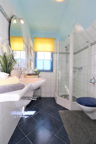a bathroom with two sinks and a shower and a toilet at Ferienhäuser Uns Lütt Hus in Dierhagen