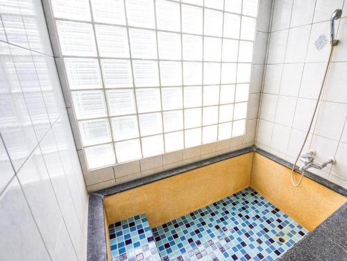 礁溪鄉的住宿－青池人文溫泉旅館，浴室铺有蓝色瓷砖地板,设有淋浴。