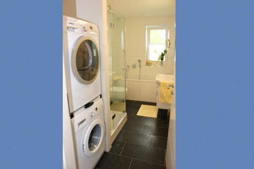 a bathroom with a washing machine and a sink at Aquamarin Ostseetraumsuite 08 in Neuhaus