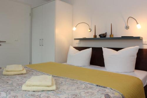 a bedroom with a large bed with two towels on it at Aquamarin Ostseetraumsuite 08 in Neuhaus