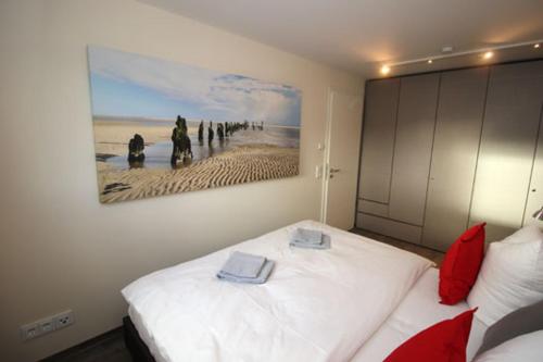 a bedroom with a bed with a painting on the wall at Aquamarin Ostseetraumsuite 10 in Neuhaus