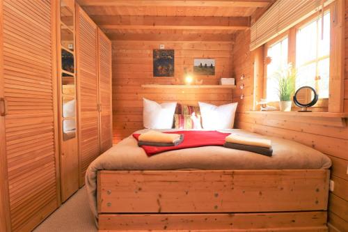 een slaapkamer met een bed in een blokhut bij Ferienhäuser Ferienhaus, Haus Auszeit in Neuhaus